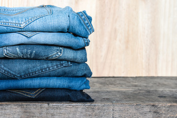Jeans stacked on a wooden table unisex trendy fashion