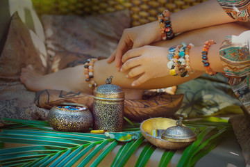 close up of woman hands and legs with jewelry