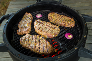 Pork steak on the grill with flames