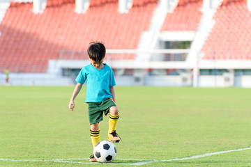 Boy and football in the football grass field