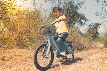 Fototapeta premium Little boy ride bicycle on the rock road.