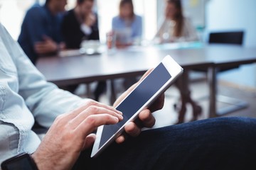 Midsection of businessman using digital tablet