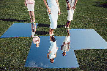 Beatiful elegant girls posing on golf course with green grass and mirrors