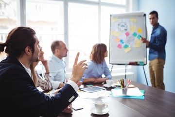 Speaker calling coworker with hand raised during meeting