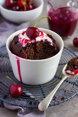 chocolate muffin with cream and cherry sauce  in a ramekin