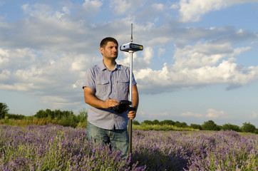 Horizontal shot of land surveyor in a lavender field