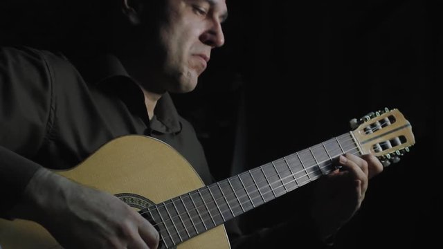 Man masterfully plays on classical acoustic guitar
