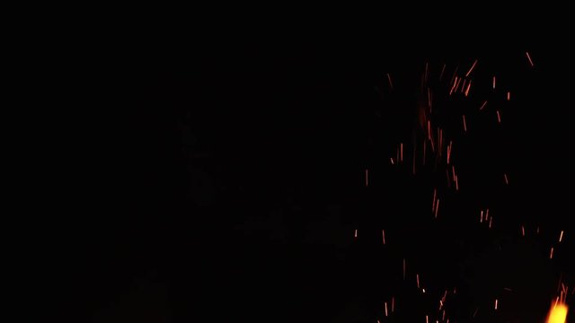 fire sparks from campfire over black background