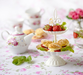 Cream puffs cakes or profiterole filled with whipped cream served with strawberries in plateau