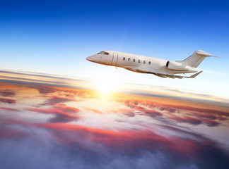 Fototapeta na wymiar Private jet plane flying above clouds