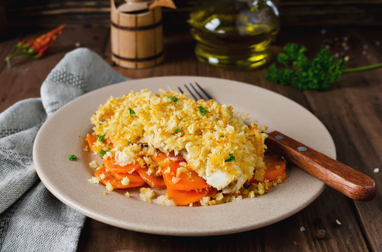 Oven-roasted fish fillet with carrots under a bread crust