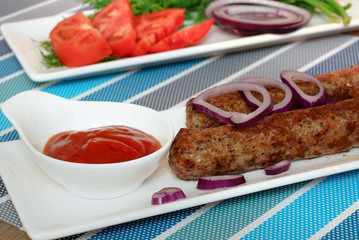 Grilled meat sausages with vegetables and ketchup. Kebab