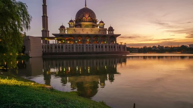 Timelapse of beautiful sunset with Putra Mosque reflected in the calm lake surface at Putrajaya, Malaysia. Motion timelapse.