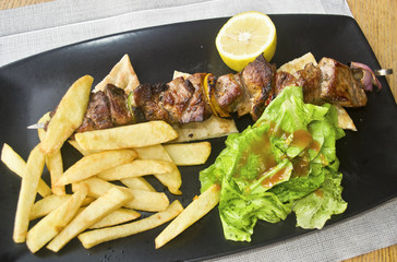 greek souvlaki with pita - pork meat with potato fries