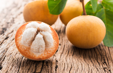 sliced santol fruit on wooden background