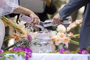 Sand ceremony vase in a wedding with colored sand being mixed together