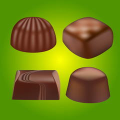 various chocolate pralines on green background
