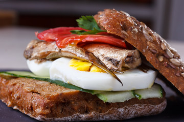 Sandwich with egg and fish, cucumber and pepper.