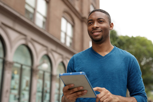 Young man in city using tablet computer