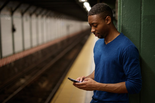 Young man in city texting cell phone