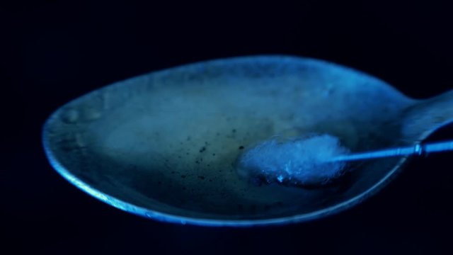Dirt heroin is filtered with cotton on a needle in a glass syringe. Macro