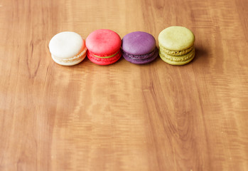 Colorful French Macarons on wooden background.