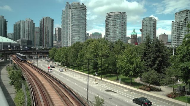 Vancouver Transit, British Columbia 4K. UHD. Downtown Vancouver skyline with the elevated rapid transit line moving commuters in and out of the city. British Columbia, Canada.
