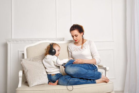 Mother and baby daughter. Listen to music