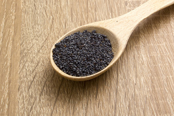 Poppy seeds in a wooden spoon