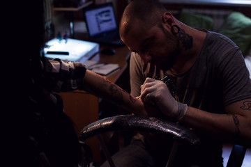 Tattooer makes tattoo for woman