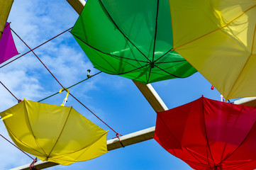 Yellow green and red umbrellas hanging reversely
