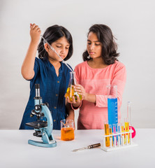 curious indian girls with microscope, asian girls with microscope, Cute little girls holding...