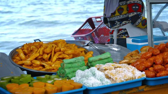 FullHD video - Variety of traditional and colorful Southeast Asian sweets, for sale at a streetside vendor's stall near the beach.