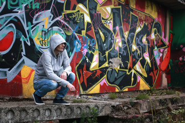 man in hoody draw graffiti