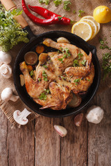 Hot Fried Chicken tobacco with herbs and garlic in a pan. Vertical top view 
