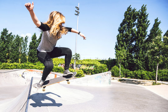Skateboarding woman practicing at skatepark