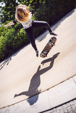 Skateboarder woman practicing ollie at park