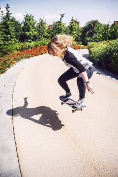 Skateboarder woman practicing ollie at park