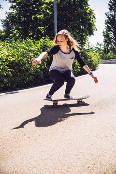 Skateboarder woman practicing ollie at park