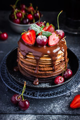 Ombre chocolate pancakes with fresh berries and chocolate sauce