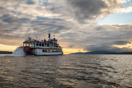 Sternwheeler going away into a beautiful sunset. Picture taken near Downtown Vancouver, BC, Canada.