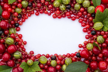Frame of fresh  berries (cherries, red and black currants, gooseberries) with green leaves