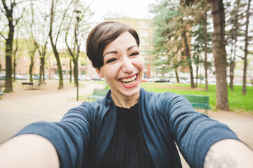 Young beautiful caucasian brown short hair woman happy taking selfie outdoor in the city -...