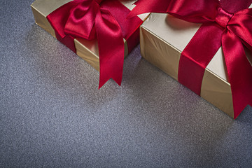 Gift boxes with red ribbons on grey background holidays concept