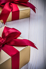Gift boxes with satin ribbons on wooden board holidays concept