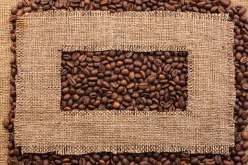 Frame made of rough burlap lies on coffee beans