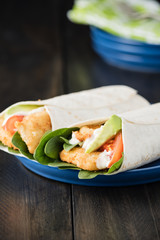 Crumbed fish fillet burrito with avocado and tomato