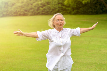 Calm woman in white clothing exercising outside