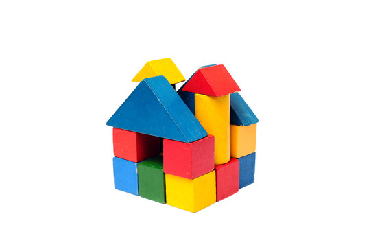 House made of old cubes. Wooden colorful building blocks isolated on white background. Vintage childrens toys.