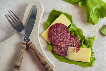 Breakfast with salami, cheese and salad on rustic background